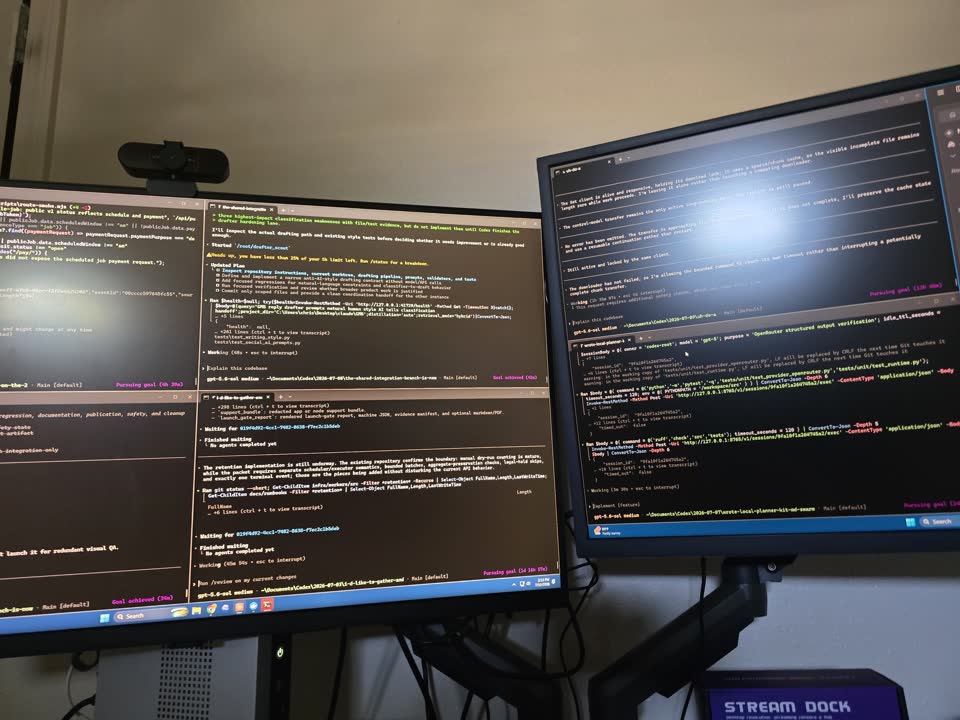 Two monitors covered in live AI agent sessions building and testing software